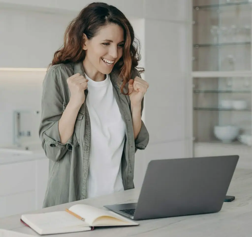 Successful female freelancer wins. Young caucasian woman says yes. Internet session on laptop.